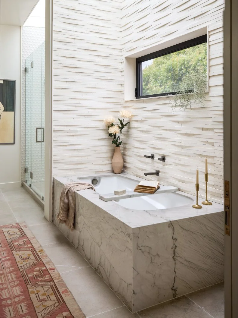 Modern White Bathroom With Limestone Tile and a Marble Tub