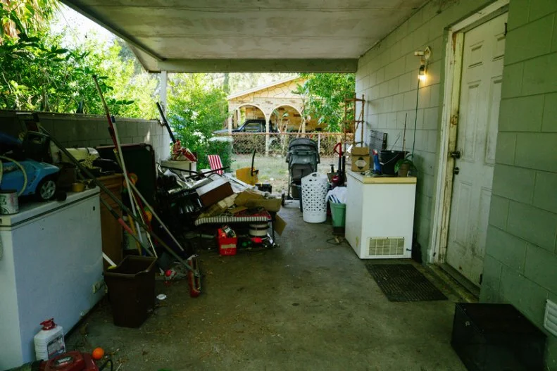 a cluttered carport seen on Worst Yard on the Block