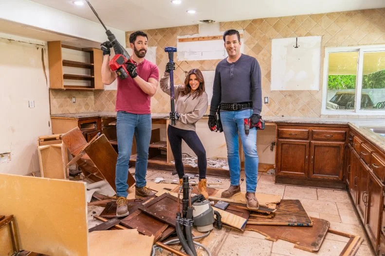 Eva Longoria poses with Drew and Jonathan Scott, as they demo the kitchen for Eva’s best friend, Bonnie, as seen on Celebrity IOU.
