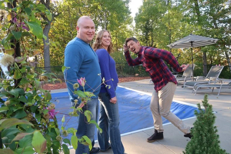 David Bromstad , in a funny pose,and winners look at camera by the pool of one possible house