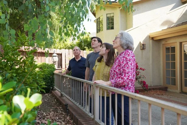 Joshua the Agent (left), steps outside with the buyers Antonio and Emilie (middle), with Emilie's mom, Mollie (right), as they examine the back of the house, Agoura Hills, CA, as seen on House Hunters, Season 273.