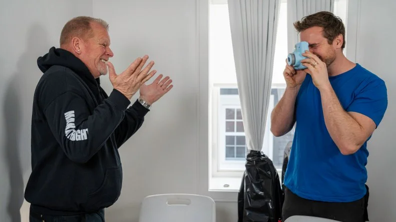 Michael snaps a polaroid of a happy Mike to put in the memory scrapbook Kimm has put together for Jay and Alicia