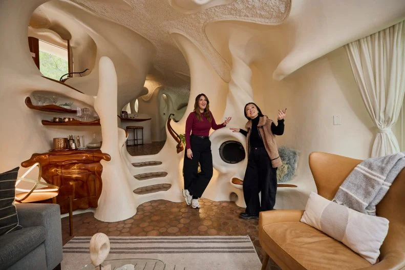 Host Sherry Cola and D’Arcy Carden in the Living Room of the Bloomhouse, as seen on Wild Vacation Rentals, Season 1.