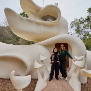 Host Sherry Cola and D’Arcy Carden at the Exterior Entry of the Bloomhouse, as seen on Wild Vacation Rentals, Season 1.
