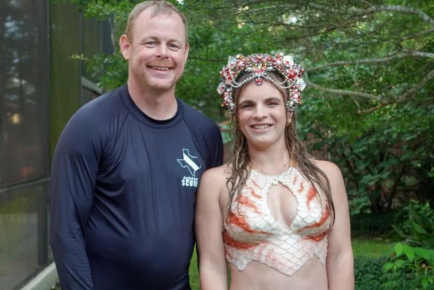 Megan with Mermaid Costume and Nate smiling  , as seen on Extreme Buyers Club, Season 1.