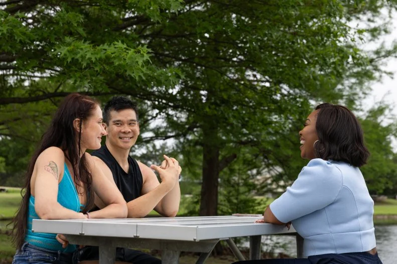 Host Noel Collier speaking with client's Mark and Anastasia in the park, as seen on Extreme Buyers Club Season 1