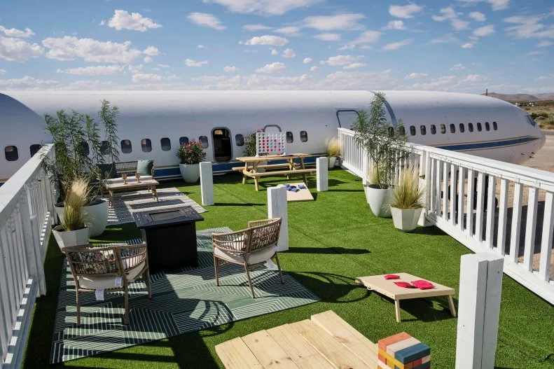 The outside deck with games and chairs made to look like a wing on a finished airplane house, as seen on Extreme Buyers Club, Season 1.