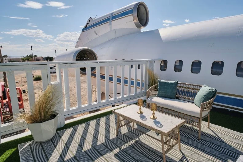 The outside deck with games and chairs made to look like a wing on a finished airplane house, as seen on Extreme Buyers Club, Season 1.