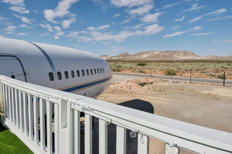 The outside deck with games and chairs made to look like a wing on a finished airplane house, as seen on Extreme Buyers Club, Season 1.
