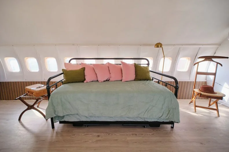 A couch that turns into a pull out bed in the first room in the finished airplane house, as seen on Extreme Buyers Club, Season 1.