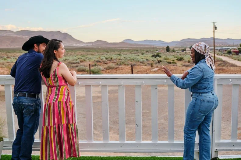 (left to right) Clients Ismael and Ruth Lara talk with host Noel Collier on the outside deck made to look like a wing at the finished airplane house, as seen on Extreme Buyers Club, Season 1.