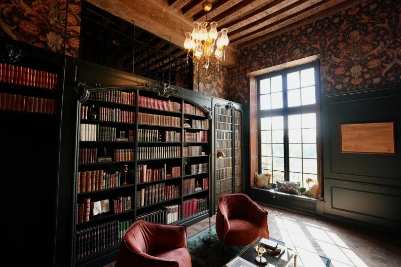 After image of revealed library, main space with chairs and bookshelves, viewed from door looking towards window (elevated), as seen on Castle Impossible, Season 2.