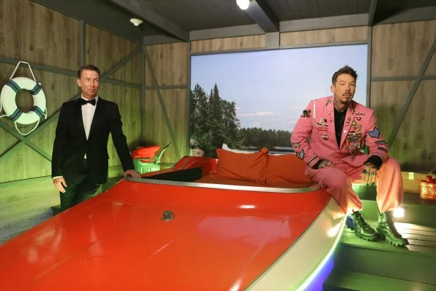 David Bromstad and Host Jack McBrayer in front of boat bed in the Regal Royale, as seen on Zillow Gone Wild, Season 3.