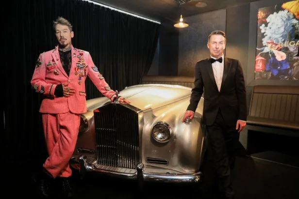 David Bromstad and Host Jack McBrayer in front of car decoration in the Regal Royale, as seen on Zillow Gone Wild, Season 3.