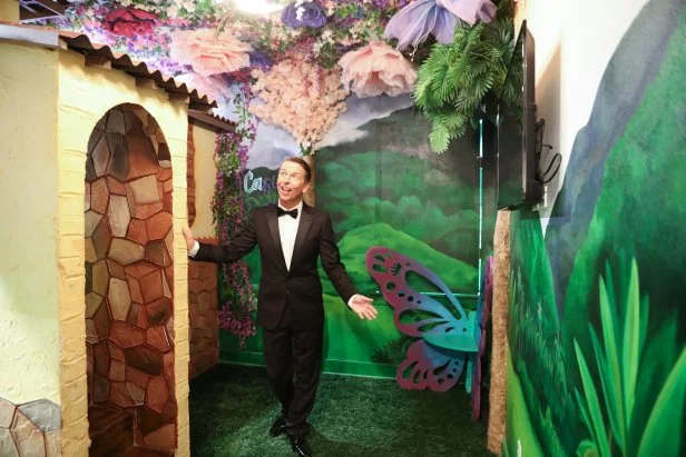 Host Jack McBrayer in a hallway with mural in the Regal Royale, as seen on Zillow Gone Wild, Season 3.