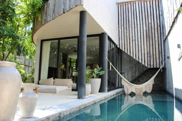 Exterior shot of pool in modern luxury home during Gabby Tomasello and Megan Weintraub's house tour, as seen on Tropic Like It's Hot, Season 1.