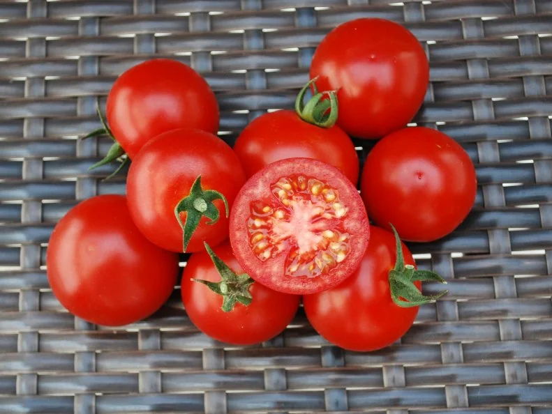 A close-up of 'Bada Bing' cherry tomatoes against a background of dark wicker