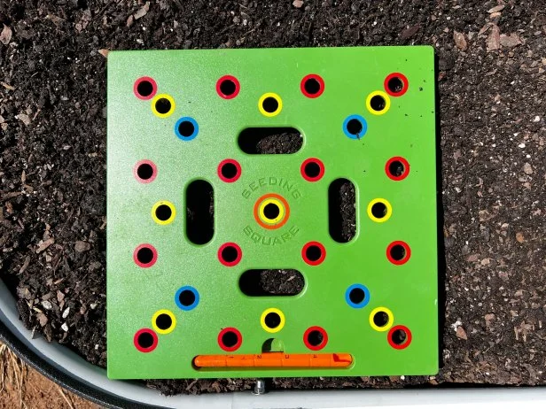 Green seeding square template placed on soil for planting