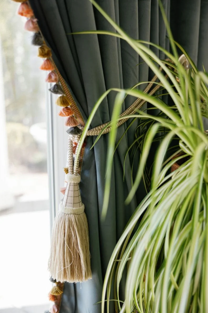 The homeowner took ordinary curtains and gave them an extraordinary look by carefully stitching on tassels that bring real elegance and attitude to the room.