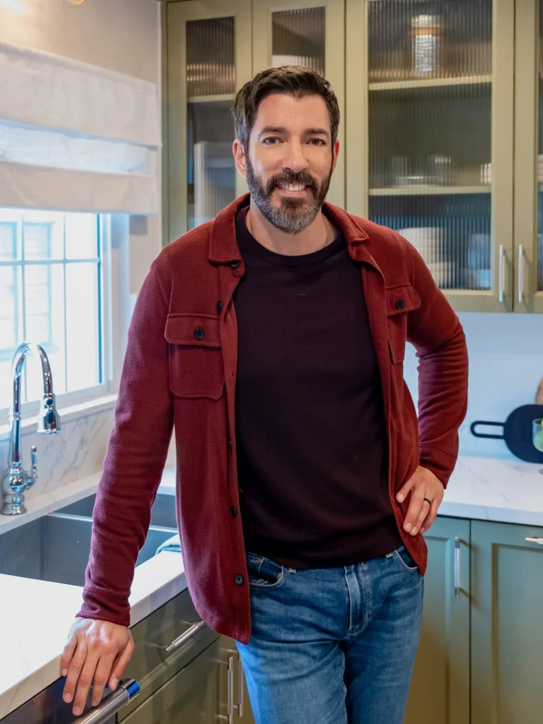 Drew posing for a photo in the kitchen after renovation as seen on Property Brothers: Under Pressure