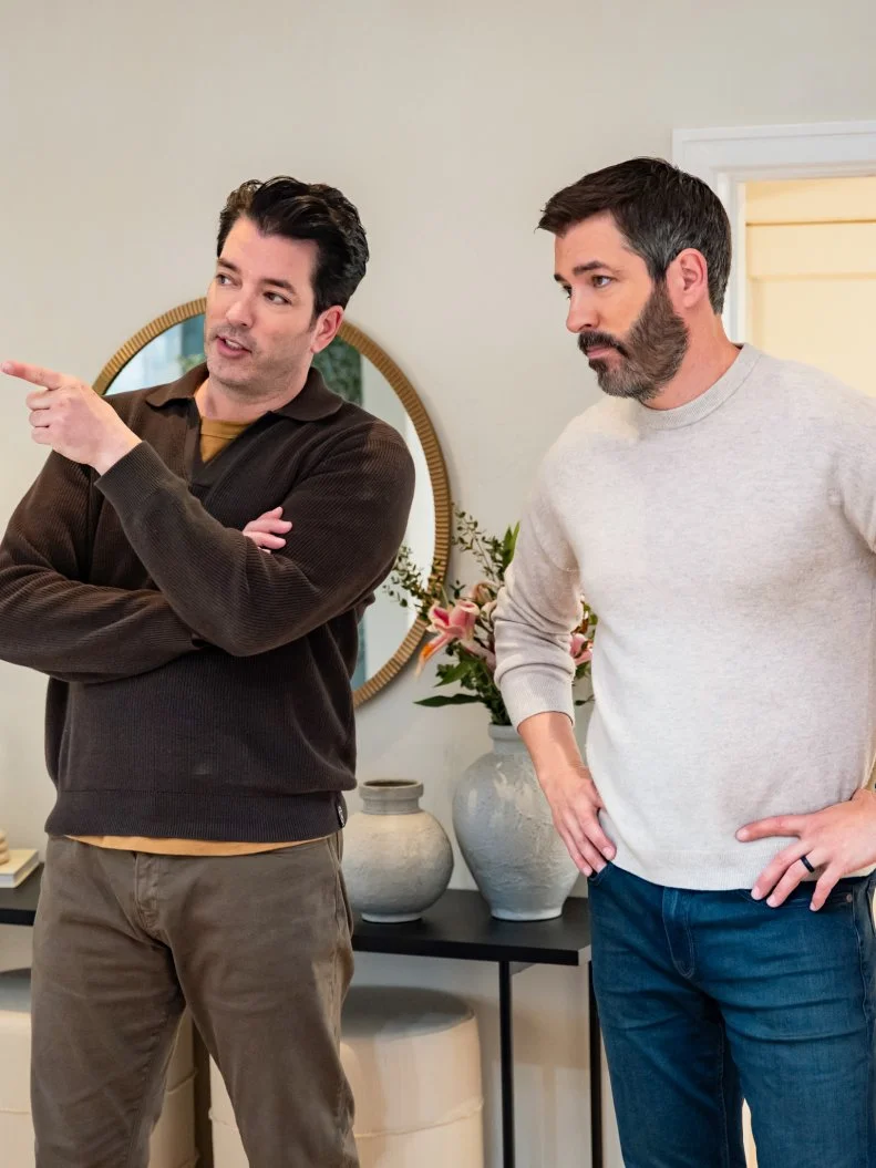 Jonathan pointing out the final details of the living room renovation to Drew as seen on Property Brothers: Under Pressure