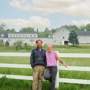 Chase and Sarah Morrill in front of the almost finished Inn, as seen on Maine Cabin Masters All Inn.