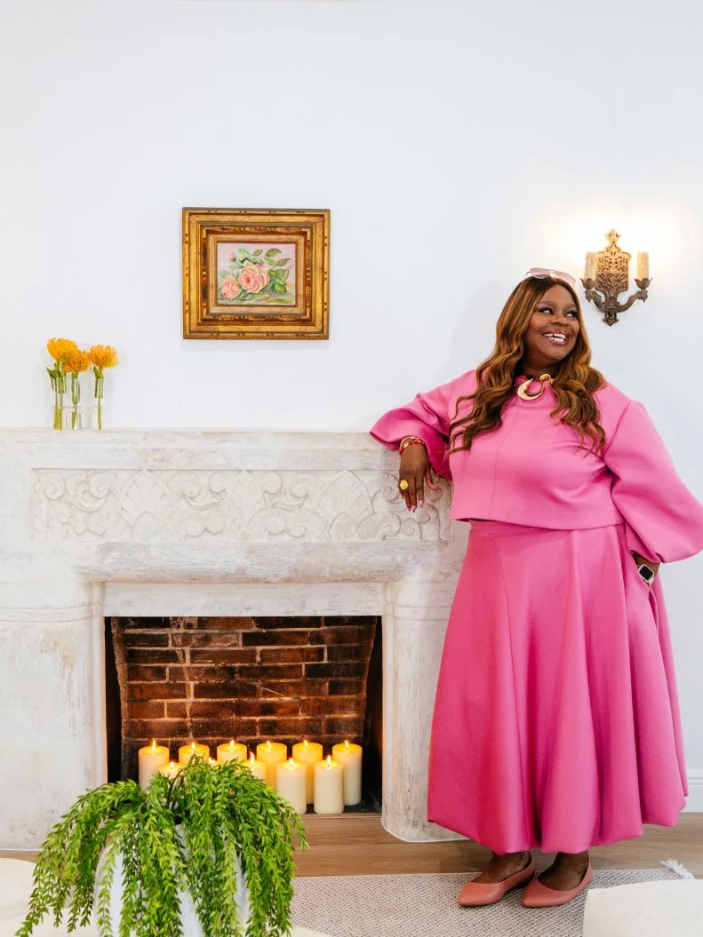 Retta in the new renovated space smiling posed to camera, at the Gaudy Greek Goddess home, as seen on Ugliest House in America, Season 8.