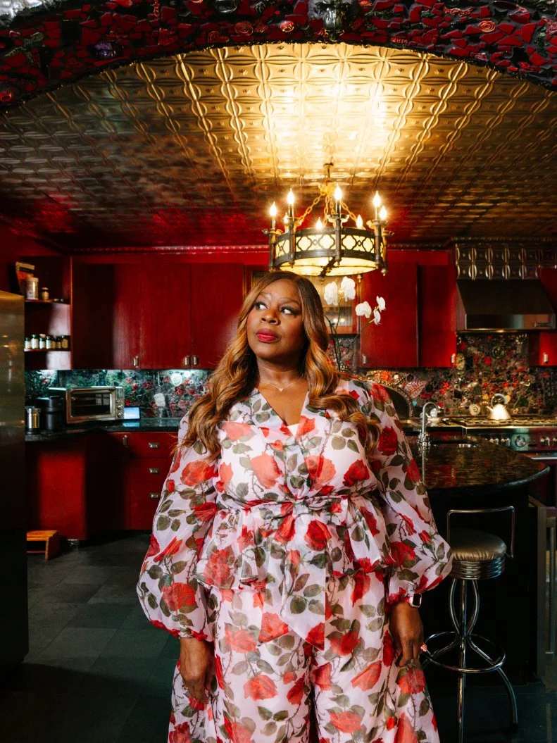 Retta in front of the tile archway infront of the kitchen in the Gaudy Greek Goddess home, as seen on Ugliest House in America, Season 8.