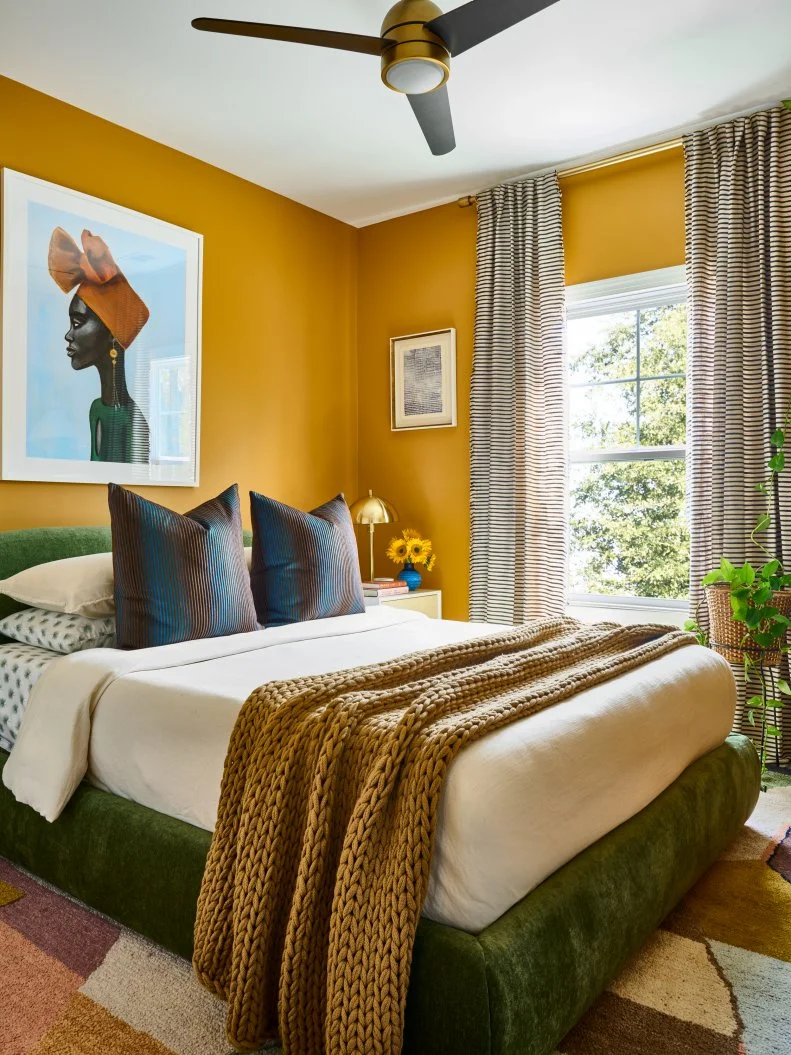 Yellow Bedroom With Green Bed, Striped Curtains and Bold Art