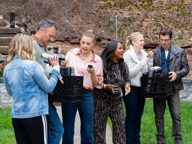 Contestants Beverley Mitchell, Brian Austin Green, Jodie Sweetin, Keshia Knight Pulliam, Melissa Joan Hart, and Matthew Lawrence look through boxes of 90's electronics, as seen on Totally 90ís House, Season 1.