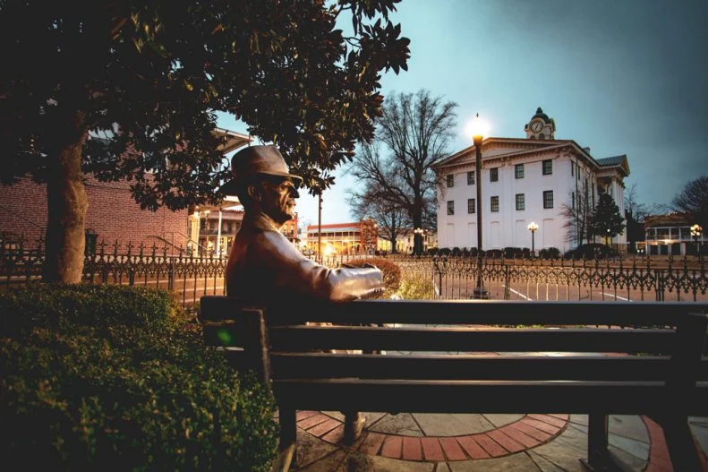 A statute of William Faulker on a bench in Oxford, MS