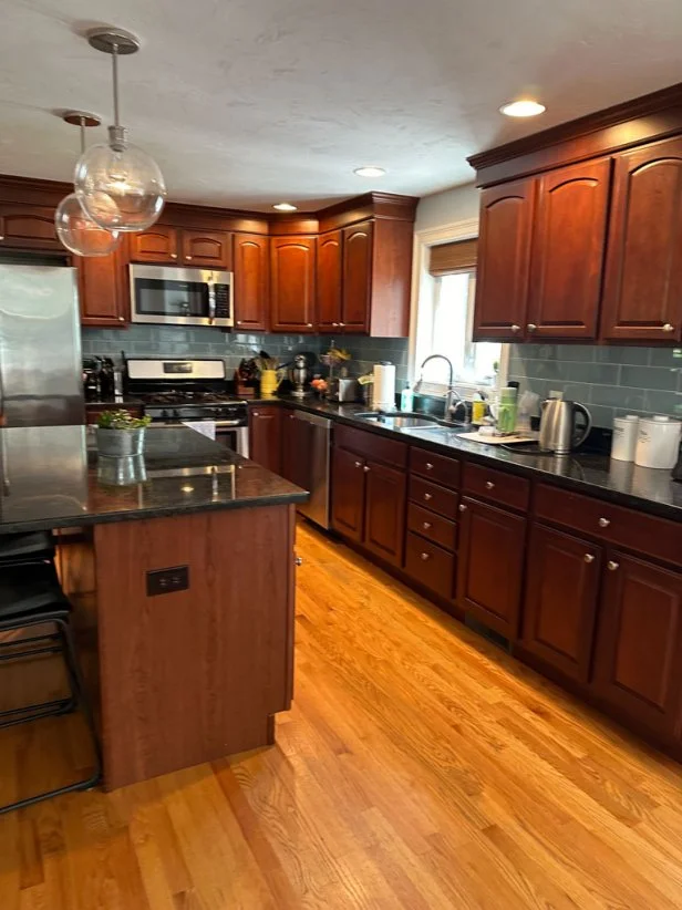 A light blue tile backsplash was the only pale color in this dark kitchen, but it felt hemmed in by the heavy wood cabinetry.