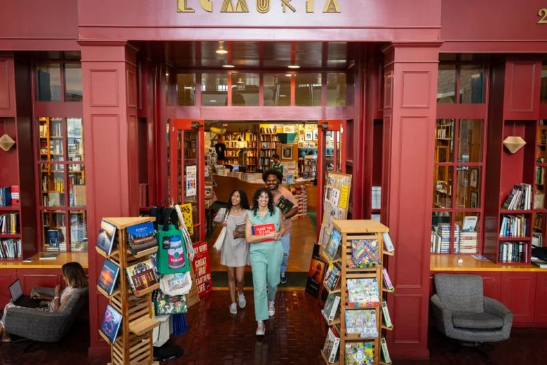 People walking out of Lemuria Books with books they've bought