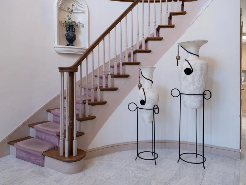 stair case with tall vases in entry way as seen on Totally 90s House, Season 1.