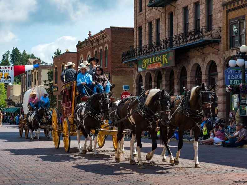 Horses and people parading in the streets for the South Dakota Days of '76 Rodeo