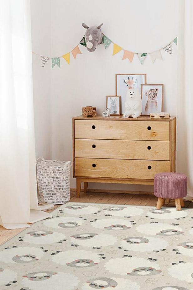 Stylish scandinavian child room with mock up photo poster frame, chest of drawers, toys, crib.Cute modern interior of playroom with white walls, wooden accessories and colorful toys.