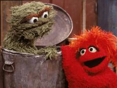 A red muppet visits Oscar the Grouch, inside his garbage can, in a scene from the children's television program 'Sesame Street,' 1980s. (Photo by Children's Television Workshop/Courtesy of Getty Images)