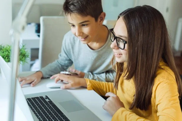 Photo of children using lap top at home