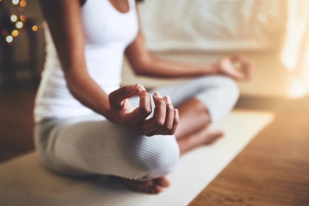 Cropped shot of an unrecognizable young woman practicing yoga indoors