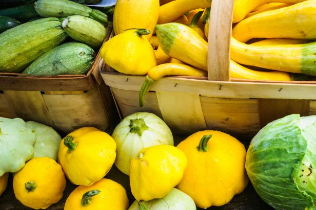 A variety of yellow and green summer squashes in baskets ready for sale at a Cape Cod farmer's Market.
