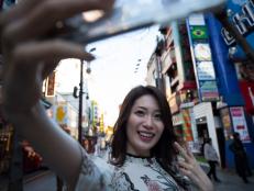 A woman takes a picture of herself on the phone.