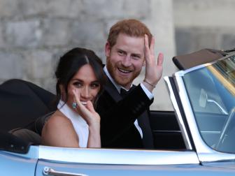 Duchess of Sussex and Prince Harry, Duke of Sussex wave as they leave Windsor Castle after their wedding to attend an evening reception at Frogmore House, hosted by the Prince of Wales on May 19, 2018 in Windsor, England.