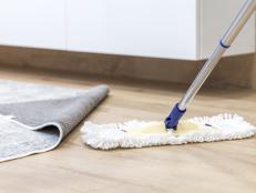Wooden floor with white a mop, cleaning service concept