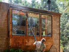 Man washing window with long pole and brush outdoors in California