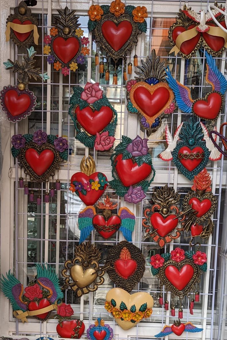 Mexican tin hearts on window at market stall