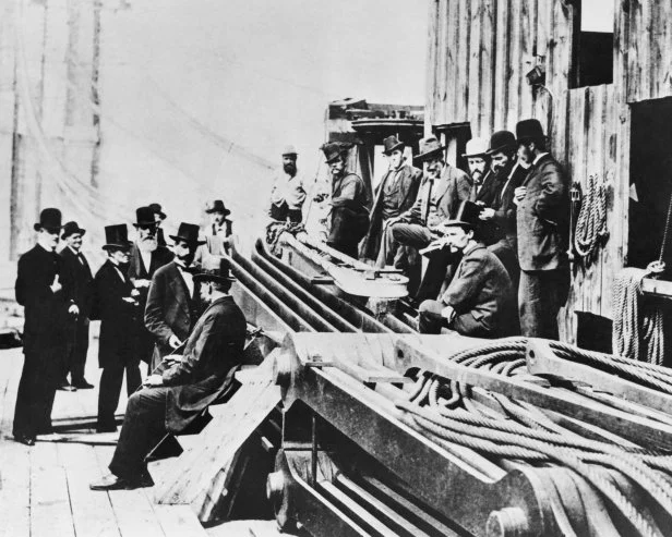 Group of officers observing construction of the Brooklyn Bridge.