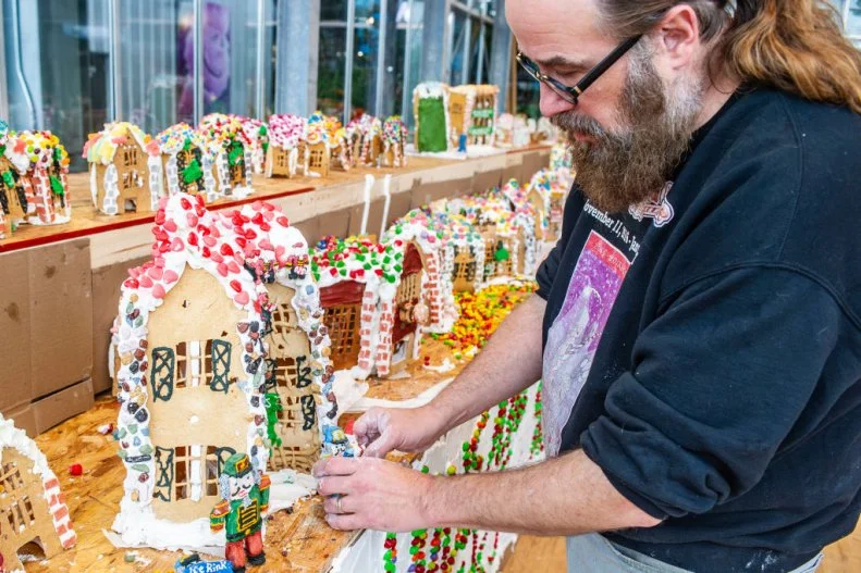 HOUSTON, TEXAS - NOVEMBER 13: Jon Lovitch places characters made entirely of icing in front of edible gingerbread dwellings that make up the giant Gingerbread Lane, Monday, Nov. 13, 2023, on display at the Houston Farmers Market on Airline Drive in Houston. (Kirk Sides/Houston Chronicle via Getty Images)