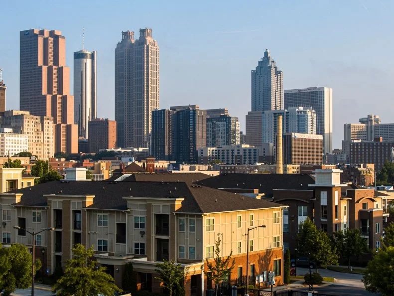 Sunlit offices towering over residential apartments in Downtown of Atlanta, Georgia, USA. Aerial view