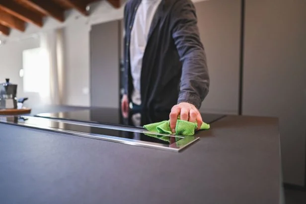 Person washes glass top cooktop with a microfiber cloth.