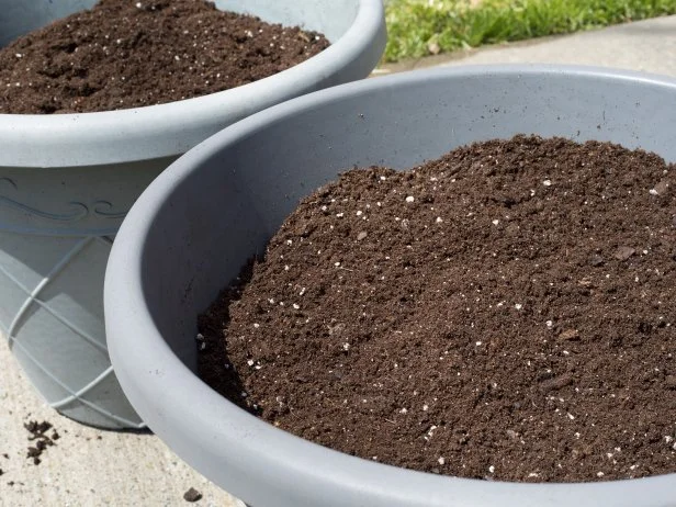 Large garden planters filled with fresh potting soil outdoors